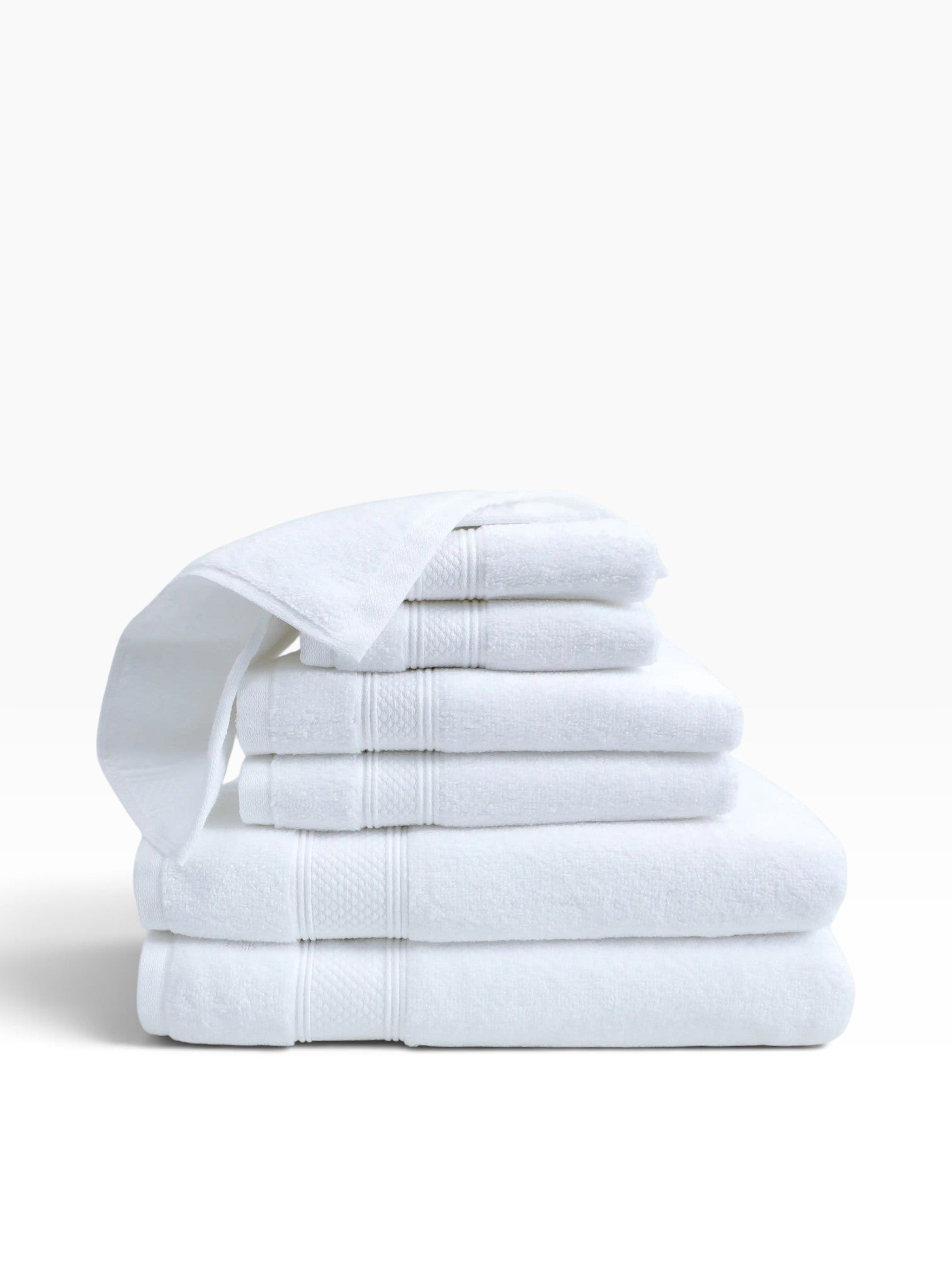 Valiant Products Atelier Zen white cotton bath mats stacked with elegant dobby borders and diamond-frame detail.
