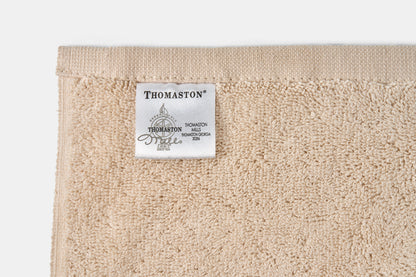 Valiant Products Unity CAM Border bath mat in beige cotton with a detailed hemmed edge and Thomaston brand label.