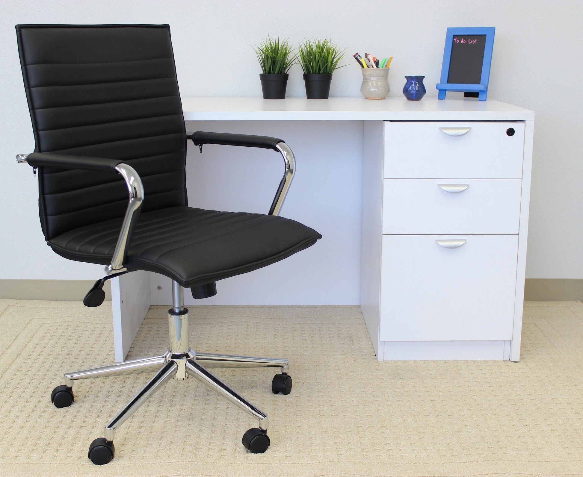 Valiant Products Brantley ergo chair in black PVC vinyl with fixed chrome arms and a chrome base in a home office.