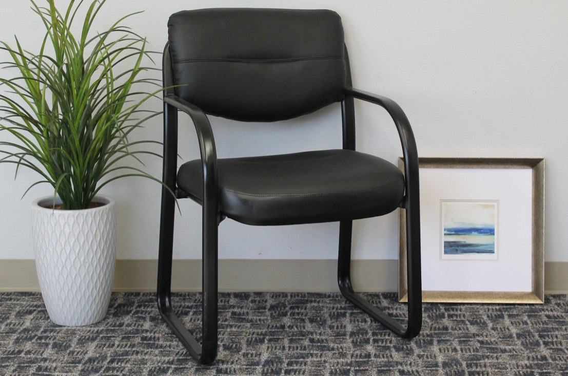 Valiant Products Conrad black leather guest chair with a sleek sled base and contoured cushions for lumbar support.