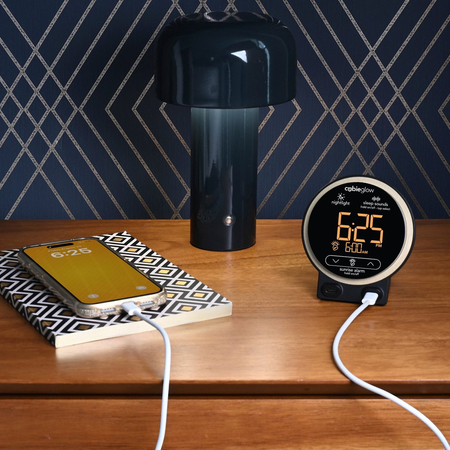 Valiant Products CubieGlow round black alarm clock with digital display and USB-C charging ports on a wooden nightstand