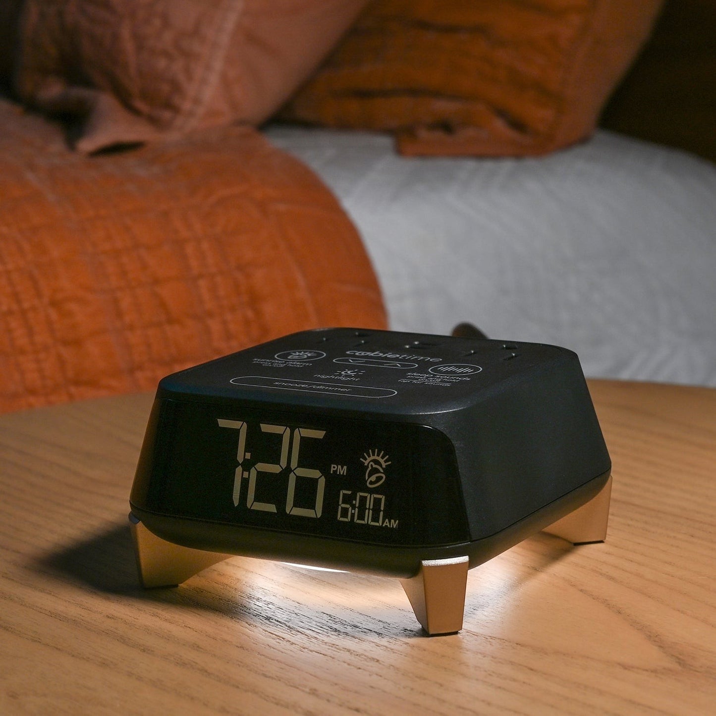 Valiant Products CubieTime Zen black alarm clock with nightlight and digital display on a wooden nightstand