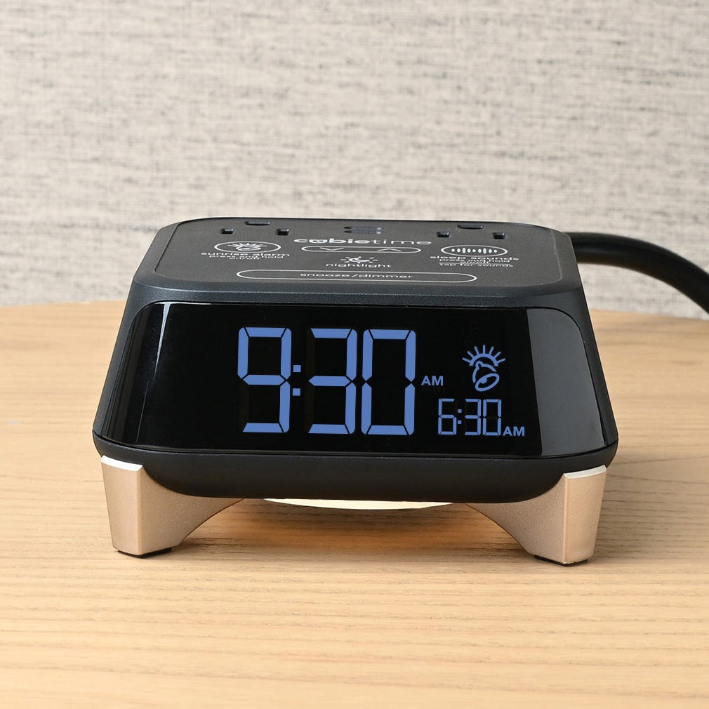 Valiant Products CubieTime Zen black alarm clock with digital display, USB ports, and power outlets on a wooden table.