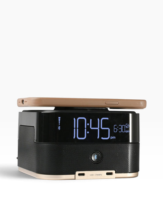 Valiant Products CubieTrio+ black alarm clock with Bluetooth speaker, USB-C ports, and wireless phone charging.