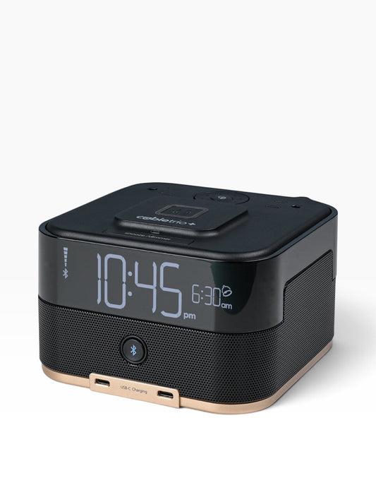 Valiant Products CubieTrio+ black alarm clock with Bluetooth speaker, wireless charging pad, and dual USB-C ports.