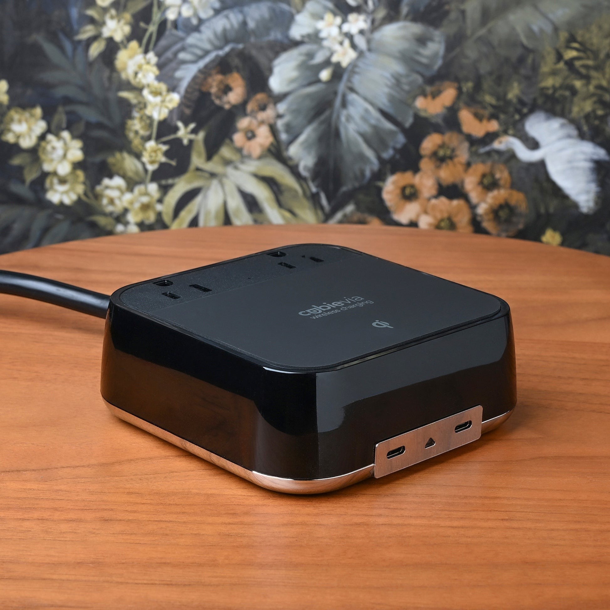 Valiant Products CubieVia black charging block with wireless charging, two USB-C ports, and AC outlets on a table.