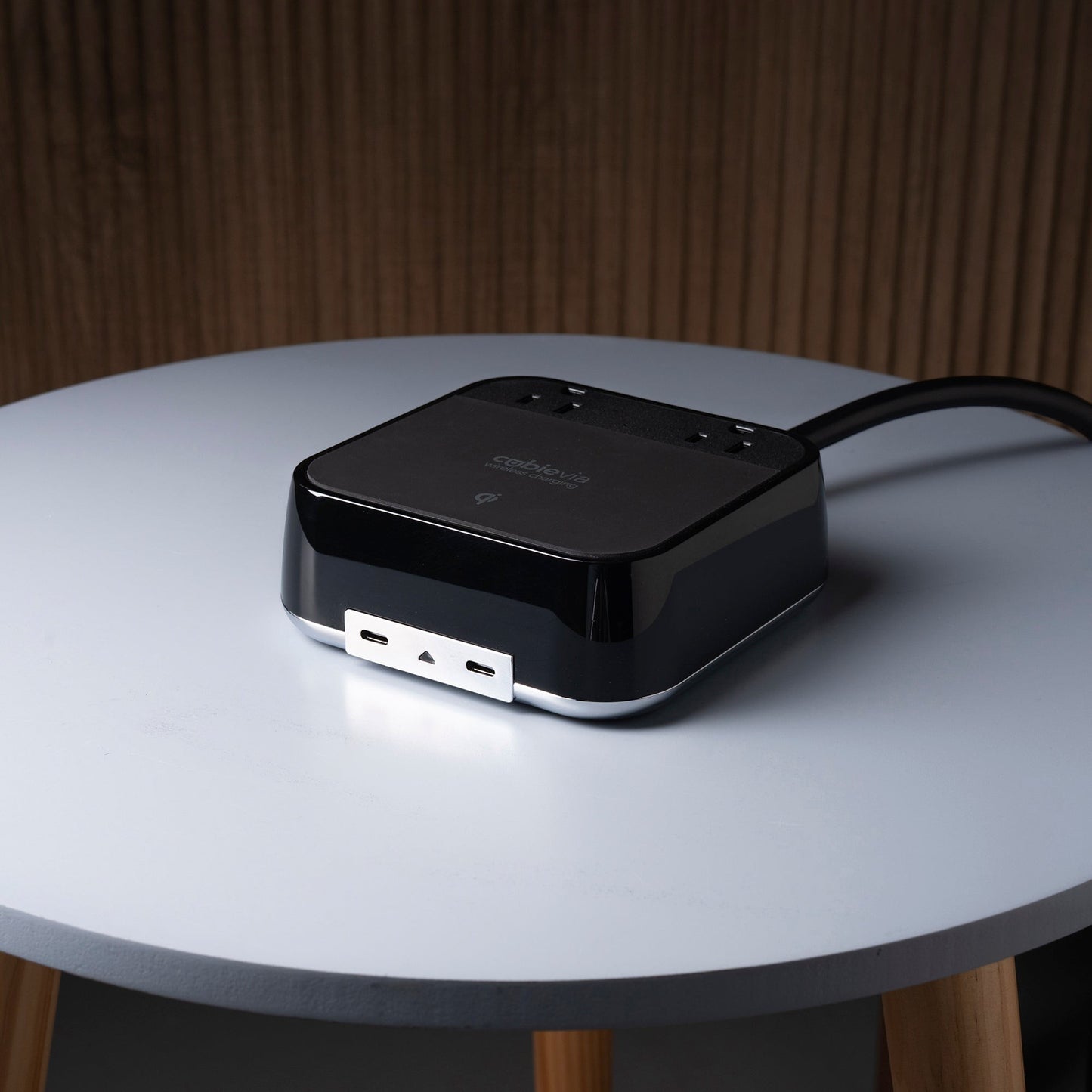 Valiant Products CubieVia black charging block with two USB-C ports and wireless charging on a small round table.