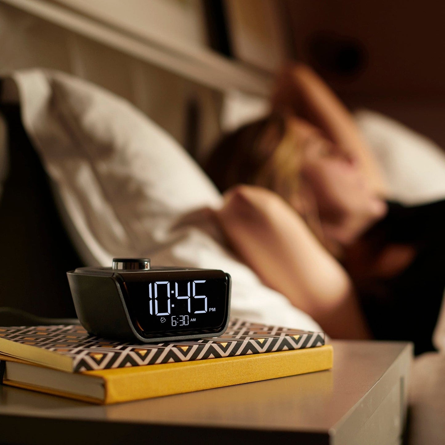 Valiant Products CubieWink black compact alarm clock with USB-C and USB-A ports on a hotel nightstand