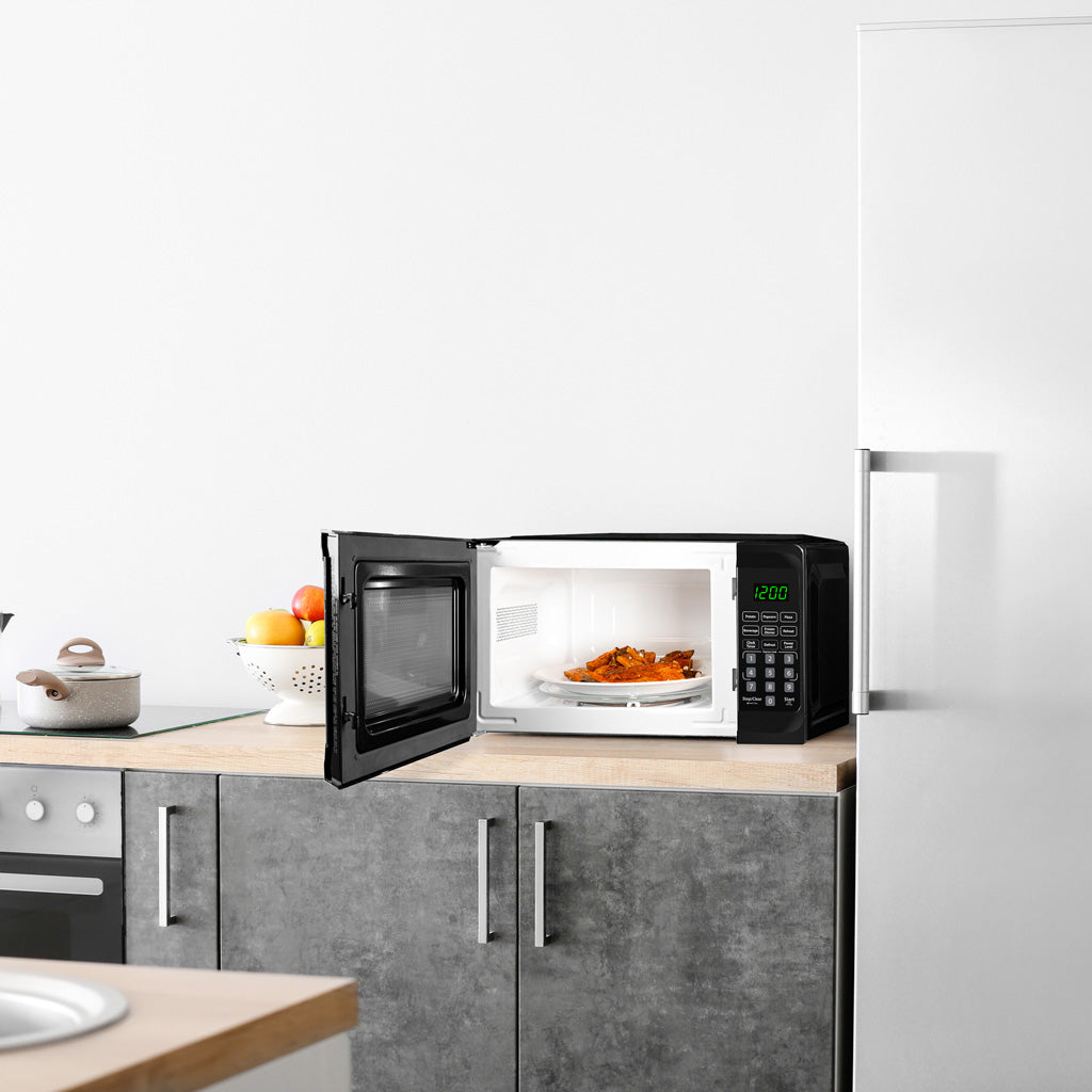 Valiant Products Danby 0.7 cu. ft. black countertop microwave with open door and glass turntable on a kitchen counter
