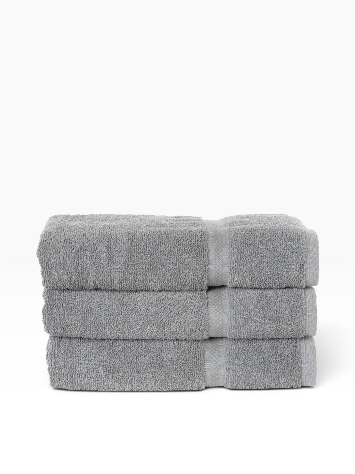 Valiant Products grey ring-spun cotton bath towels with a decorative dobby border, stacked neatly.