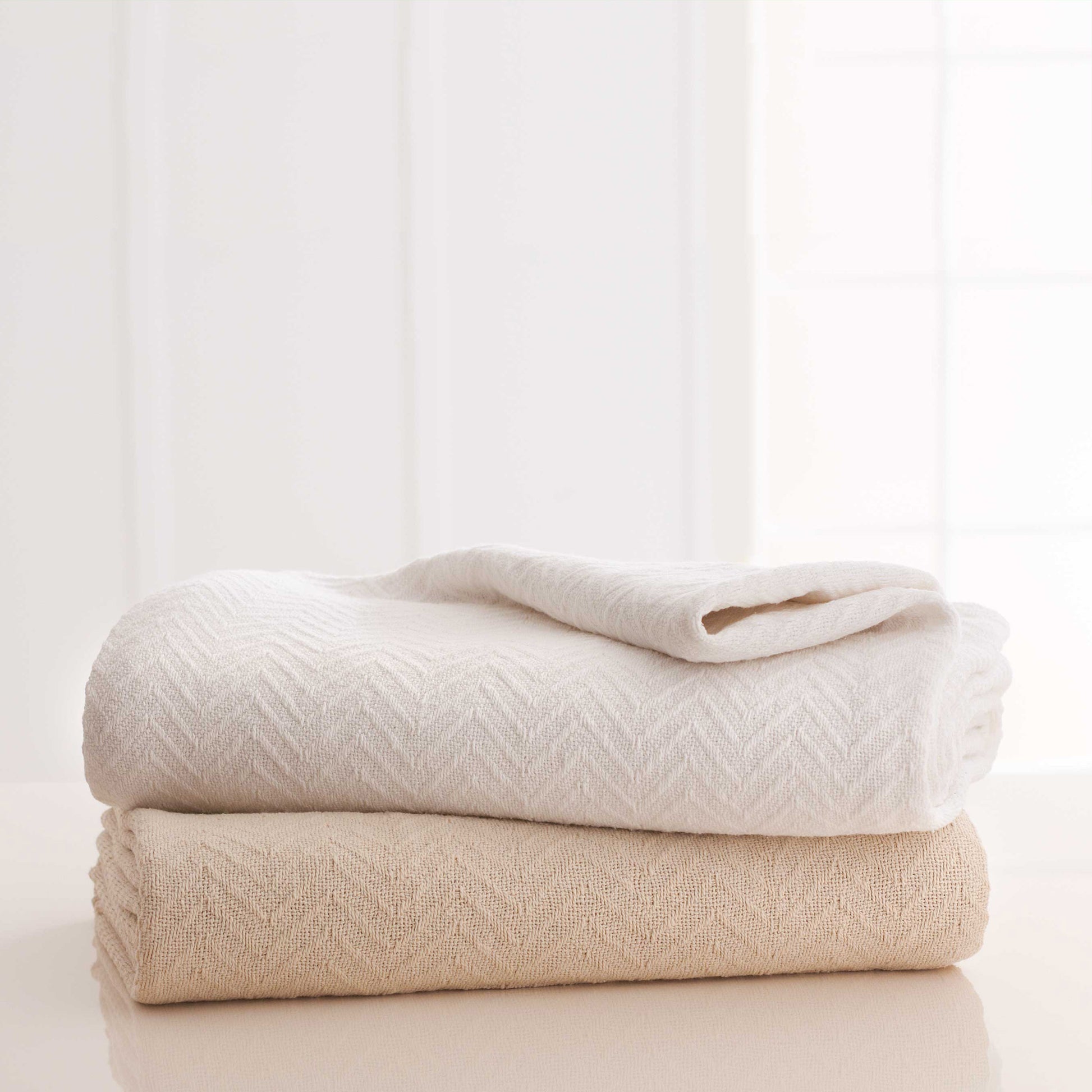 Valiant Products Grand Patrician cotton blankets in white and natural with a classic herringbone weave pattern.