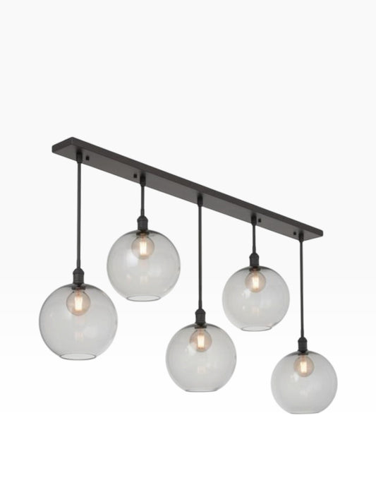Valiant Products Luma pendant light featuring five smoked grey glass globe shades on a bronze linear canopy