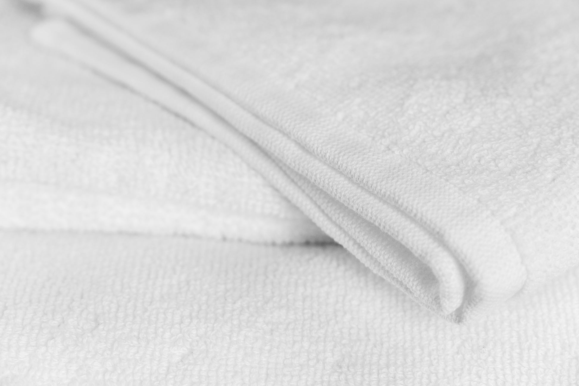Valiant Products Luxe borderless white bath towel made from 100% ring-spun cotton with a soft, absorbent texture.