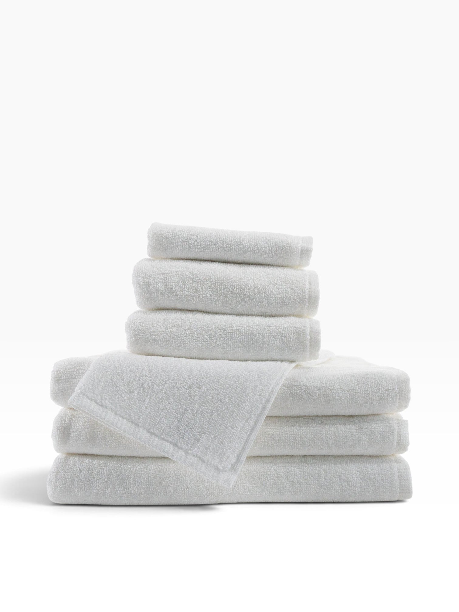 Valiant Products Luxe white borderless cotton bath towels stacked neatly for a clean European hospitality aesthetic.