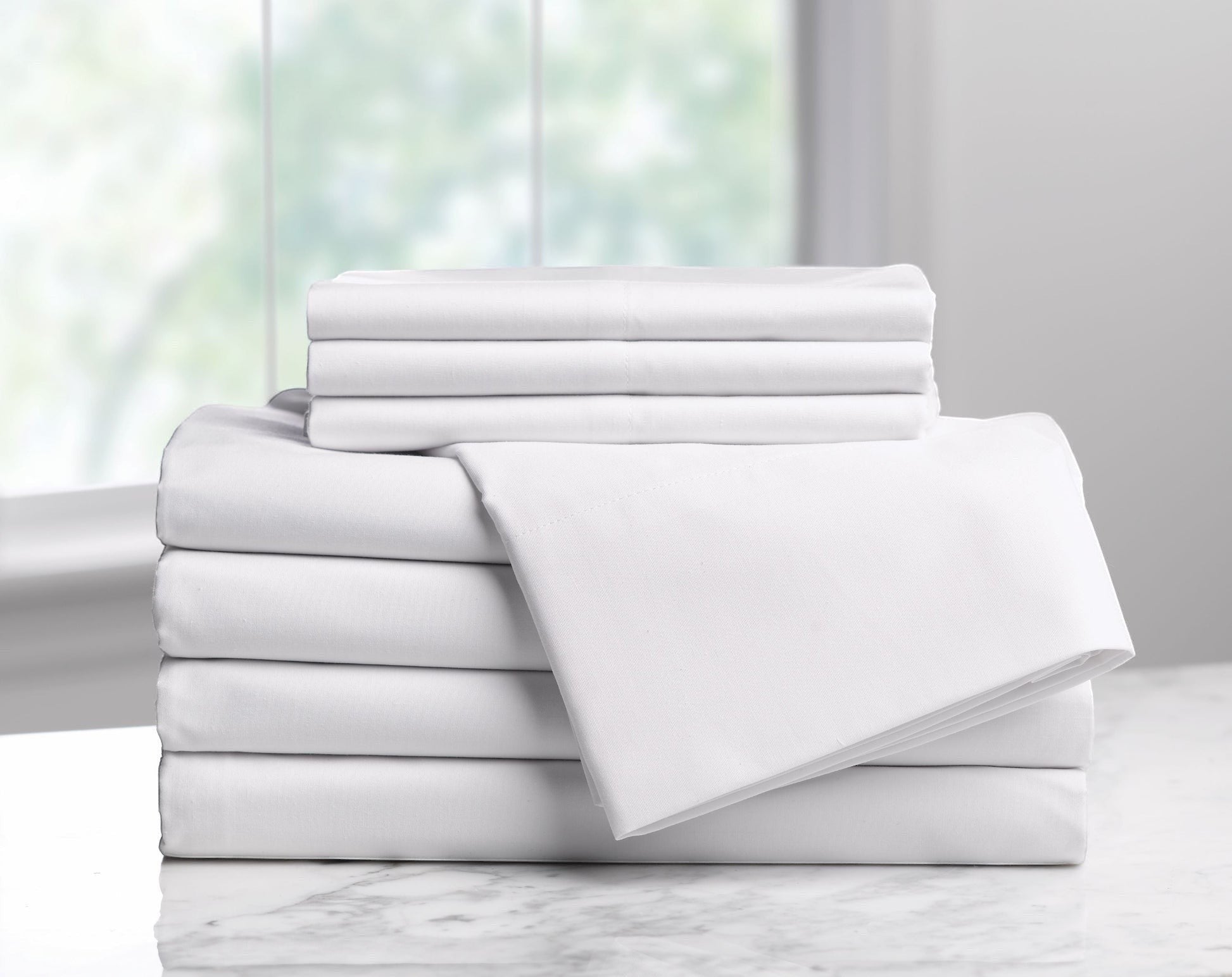 Valiant Products Millennium 300 thread count white cotton-blend flat sheets stacked neatly on a marble surface.