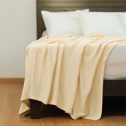 Valiant Products Atelier Luxe natural cotton and TENCEL blend blanket with a refined herringbone weave on a bed