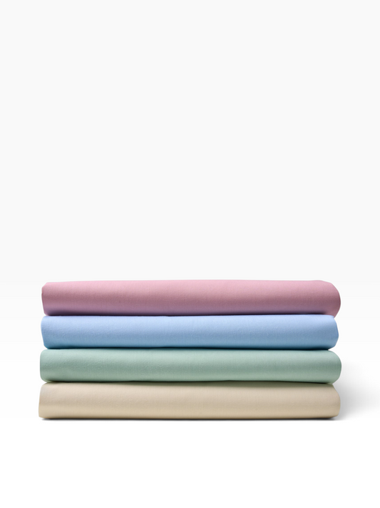 Valiant Products T-180 percale flat sheets in rose, light blue, seafoam green, and bone stacked on a white background.