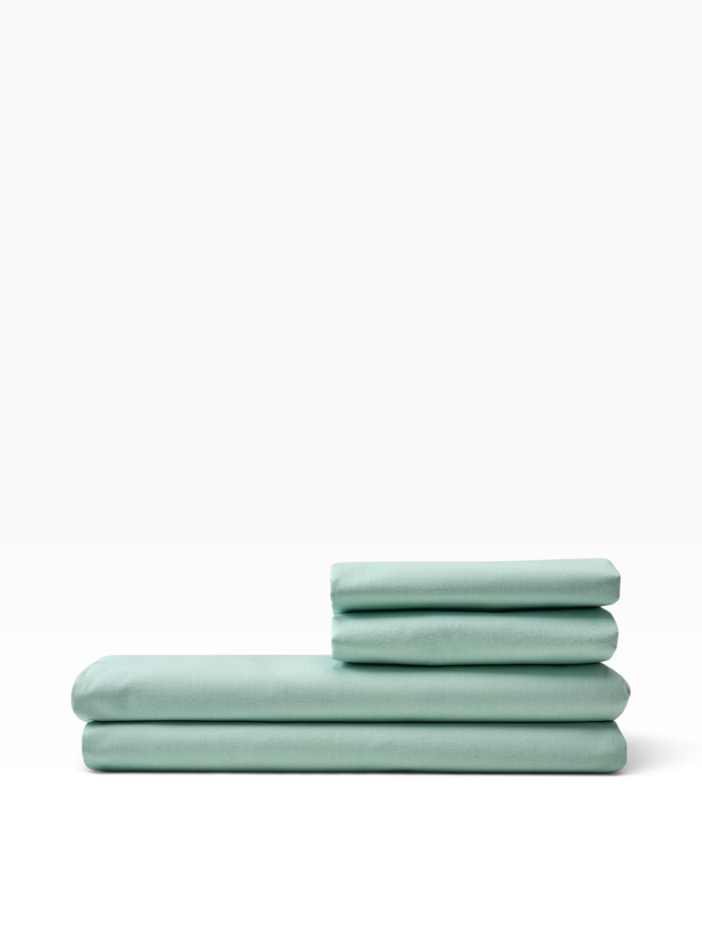 Valiant Products seafoam green 180 thread count percale flat sheets folded in a neat stack on a white background.