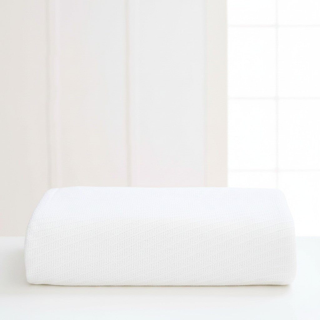 Valiant Products Sovereign white 100% cotton blanket with a tight diagonal weave, folded neatly on a white surface.