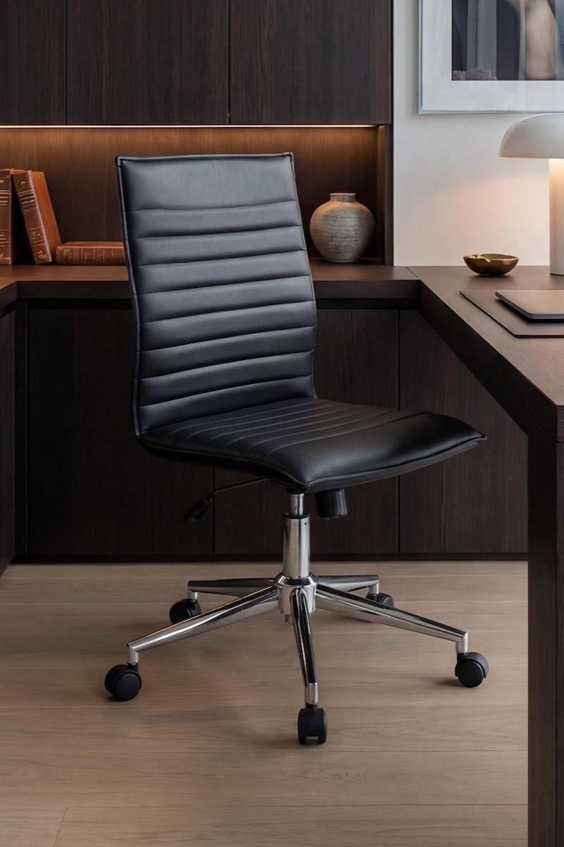 Valiant Products Starling armless ergo chair in black PVC vinyl with a chrome base in a modern home office setting.