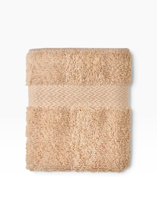 Valiant Products Royal Suite tan washcloth with a textured dobby border and absorbent cotton terry loop surface