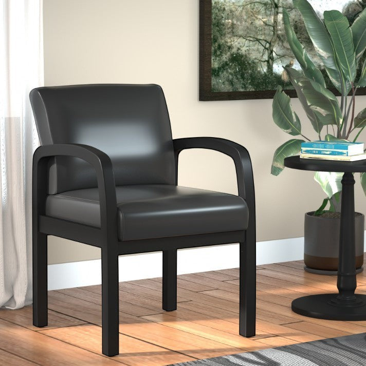 Valiant Products Tiernan guest chair with black antimicrobial vinyl upholstery and a sleek black wood frame.