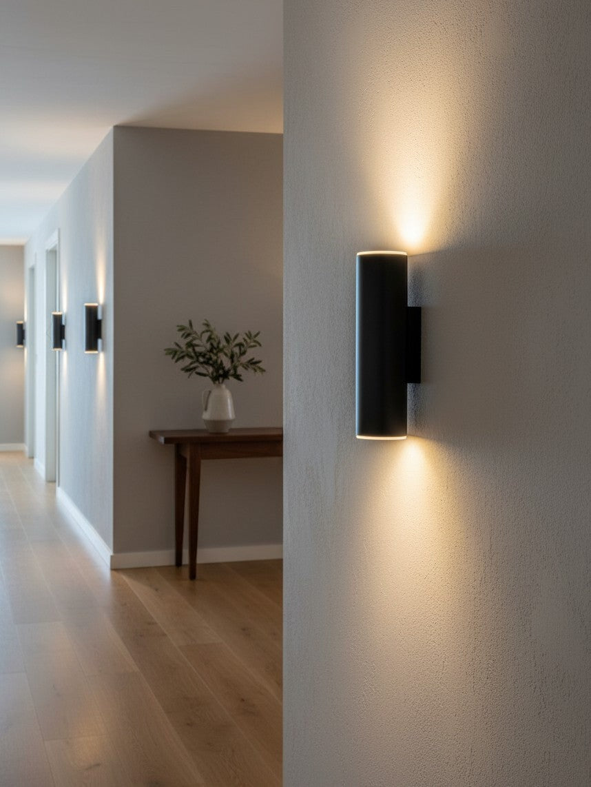 Valiant Products Totem matte black LED wall sconce casting warm up and down light in a modern hallway