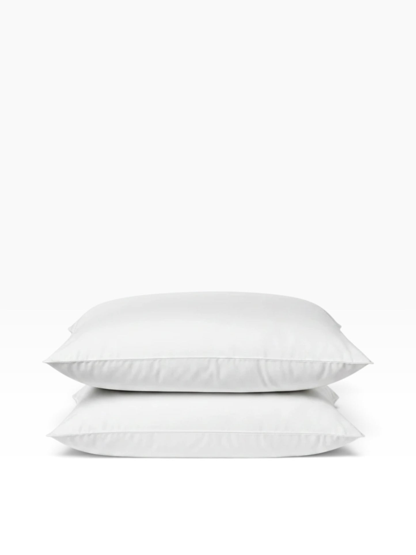 Valiant Products Ultra Touch white microfiber pillows stacked, featuring eco-conscious recycled fiberfill.