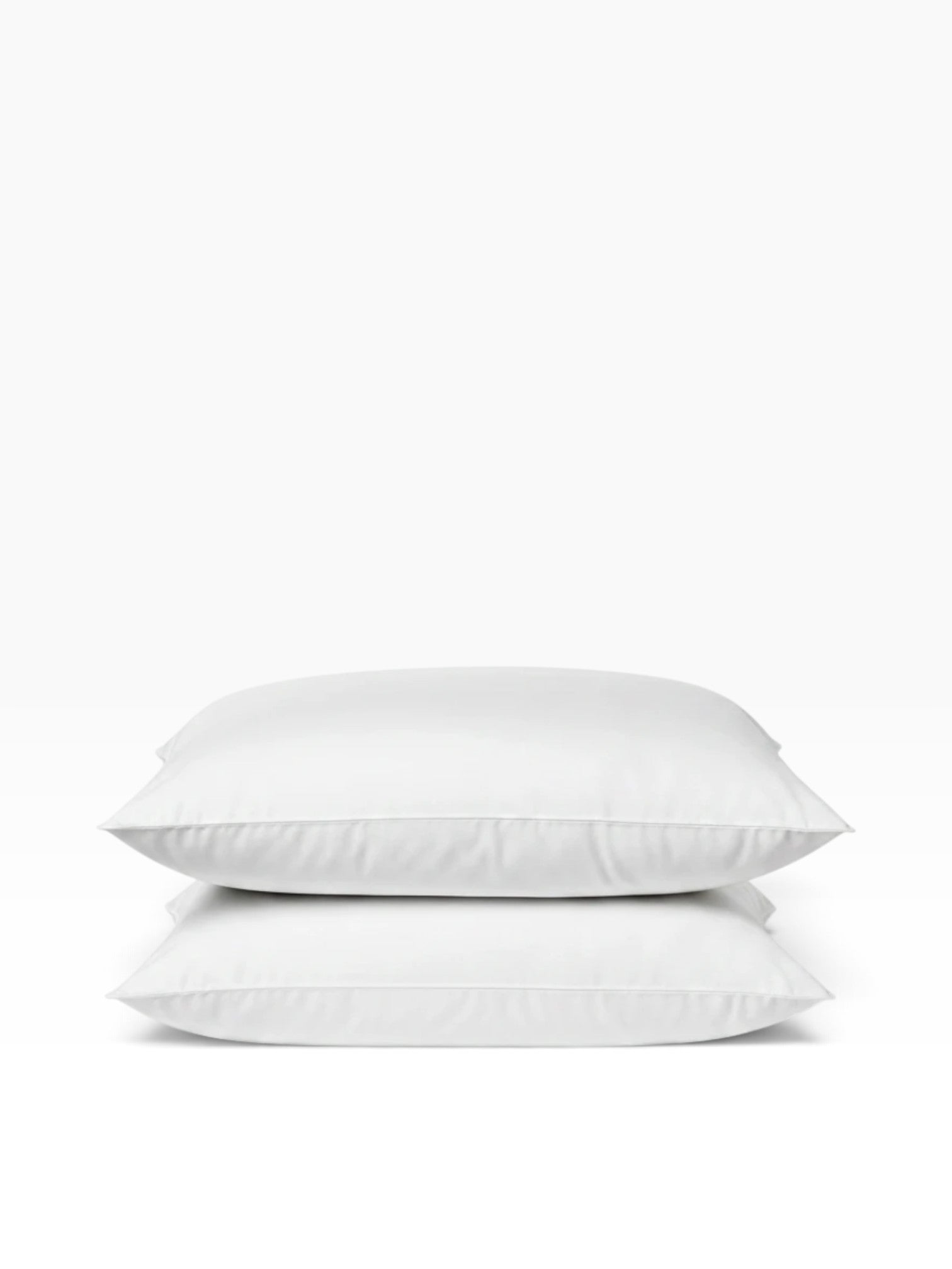 Valiant Products Ultra Touch white microfiber pillows stacked, featuring eco-conscious recycled fiberfill.