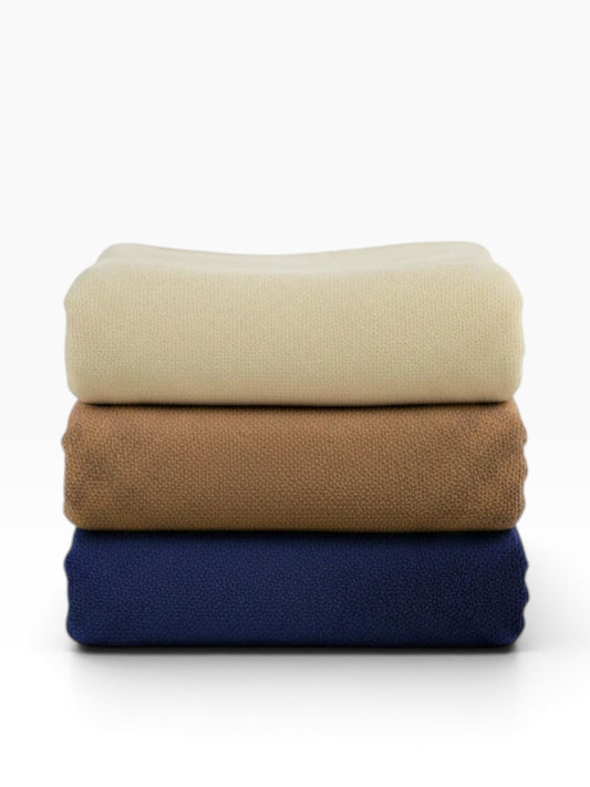 Valiant Products Vellux Renew polyester chenille blankets stacked in navy, tan, and ivory for hospitality use.