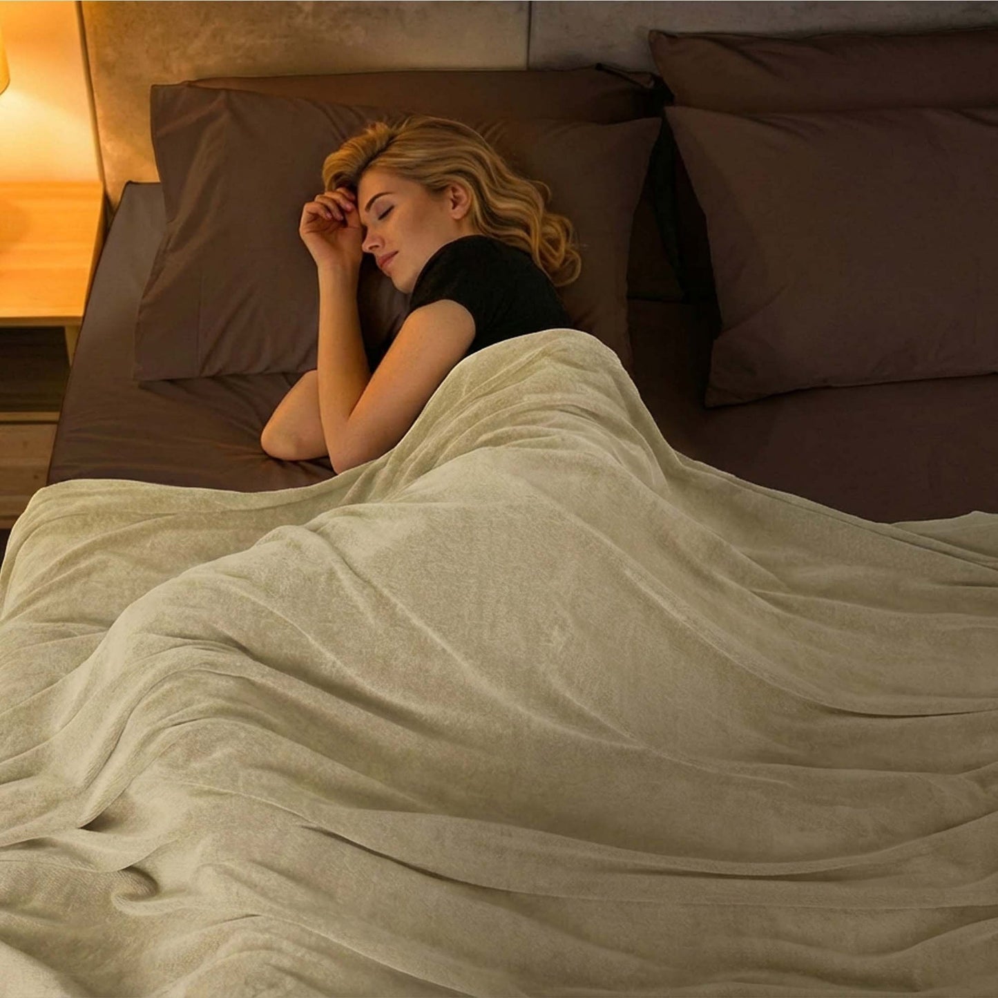 Valiant Products Vellux Renew polyester chenille blanket in tan, draped over a woman sleeping in a hotel bed.
