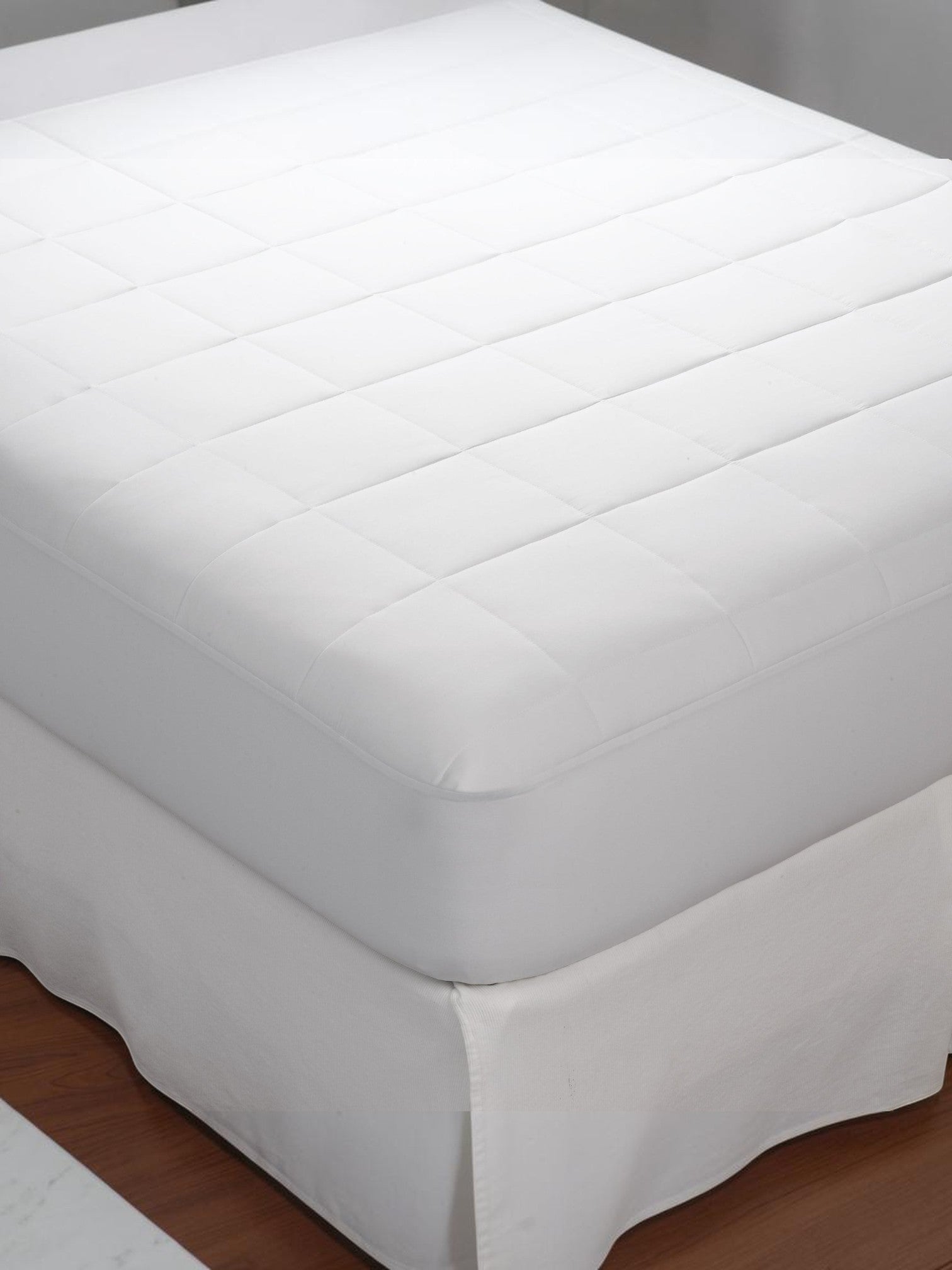 Valiant Products Silent Choice Plus white quilted waterproof mattress pad with soft microfiber surface on a bed.