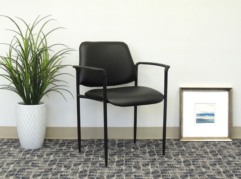 Valiant Products Whitaker black vinyl stacking chair with fixed arms and a sturdy tubular steel frame.