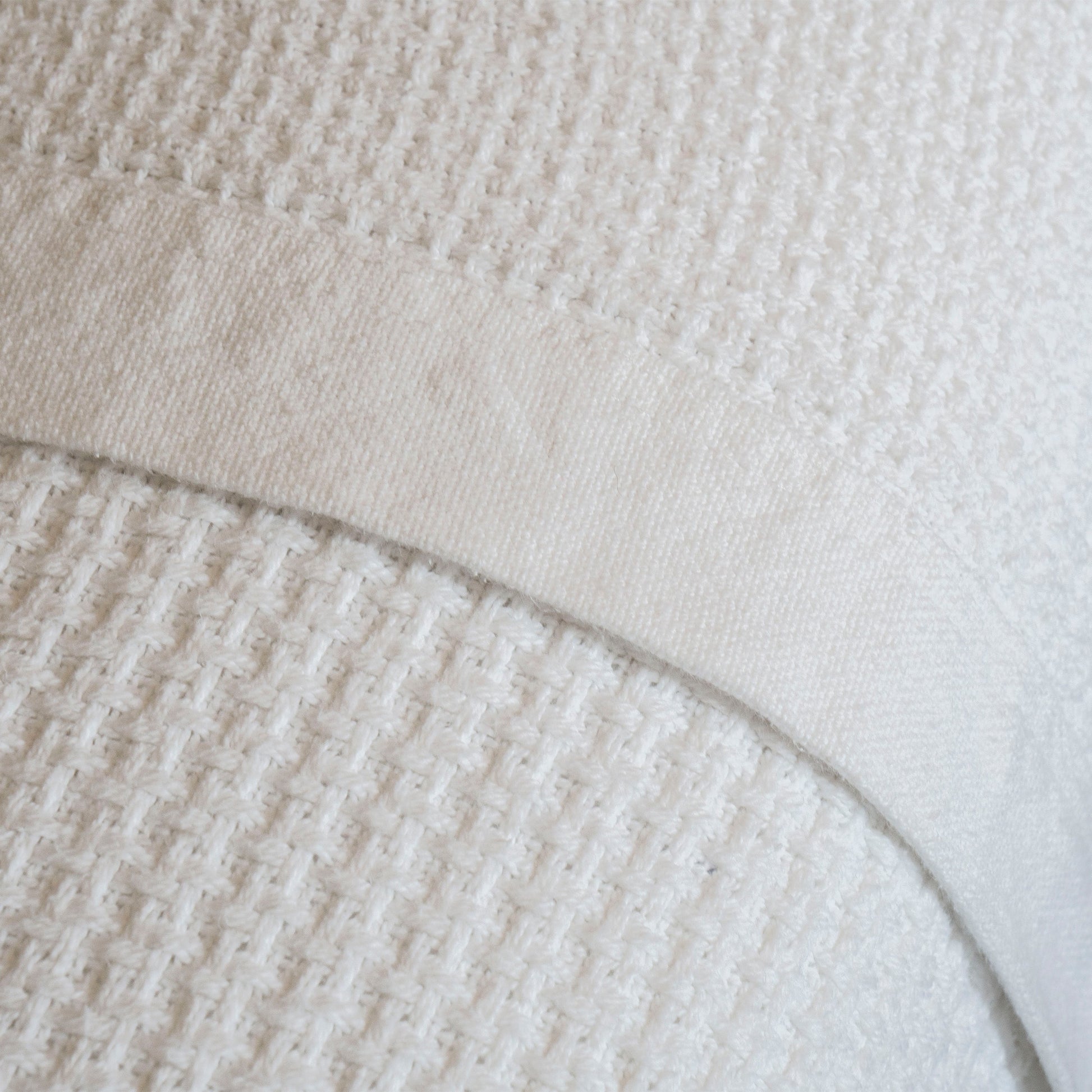 Valiant Products white cotton blanket featuring a textured basketweave pattern and a smooth tailored hem finish.