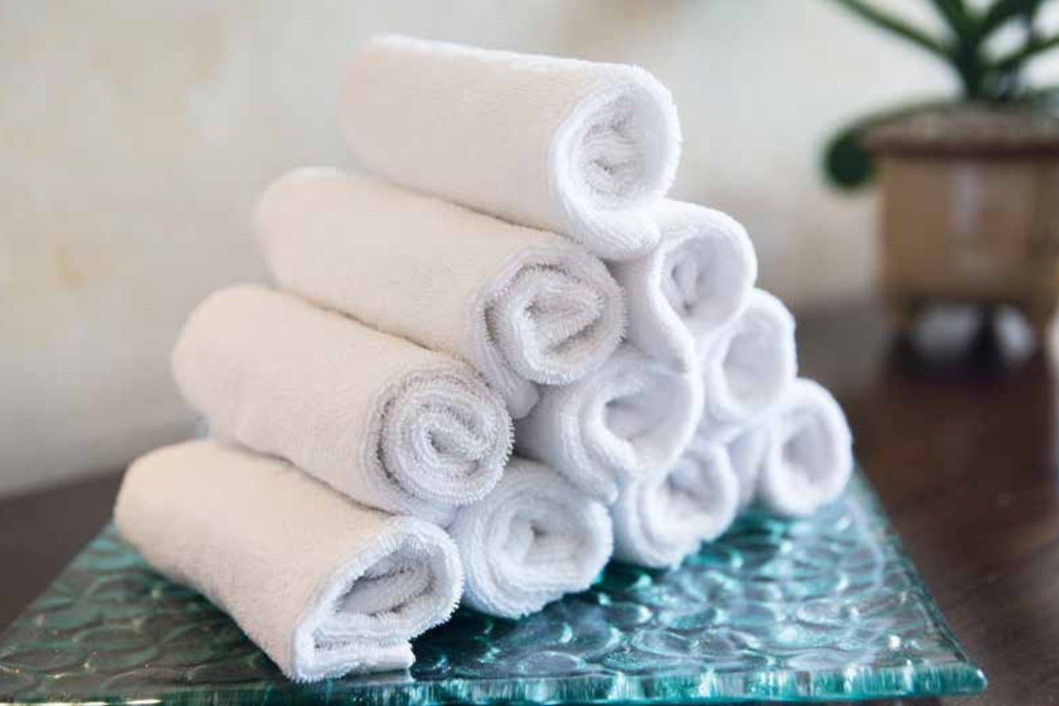 Valiant Products white Unity CAM border hand towels stacked in a neat pyramid for commercial or hospitality use.