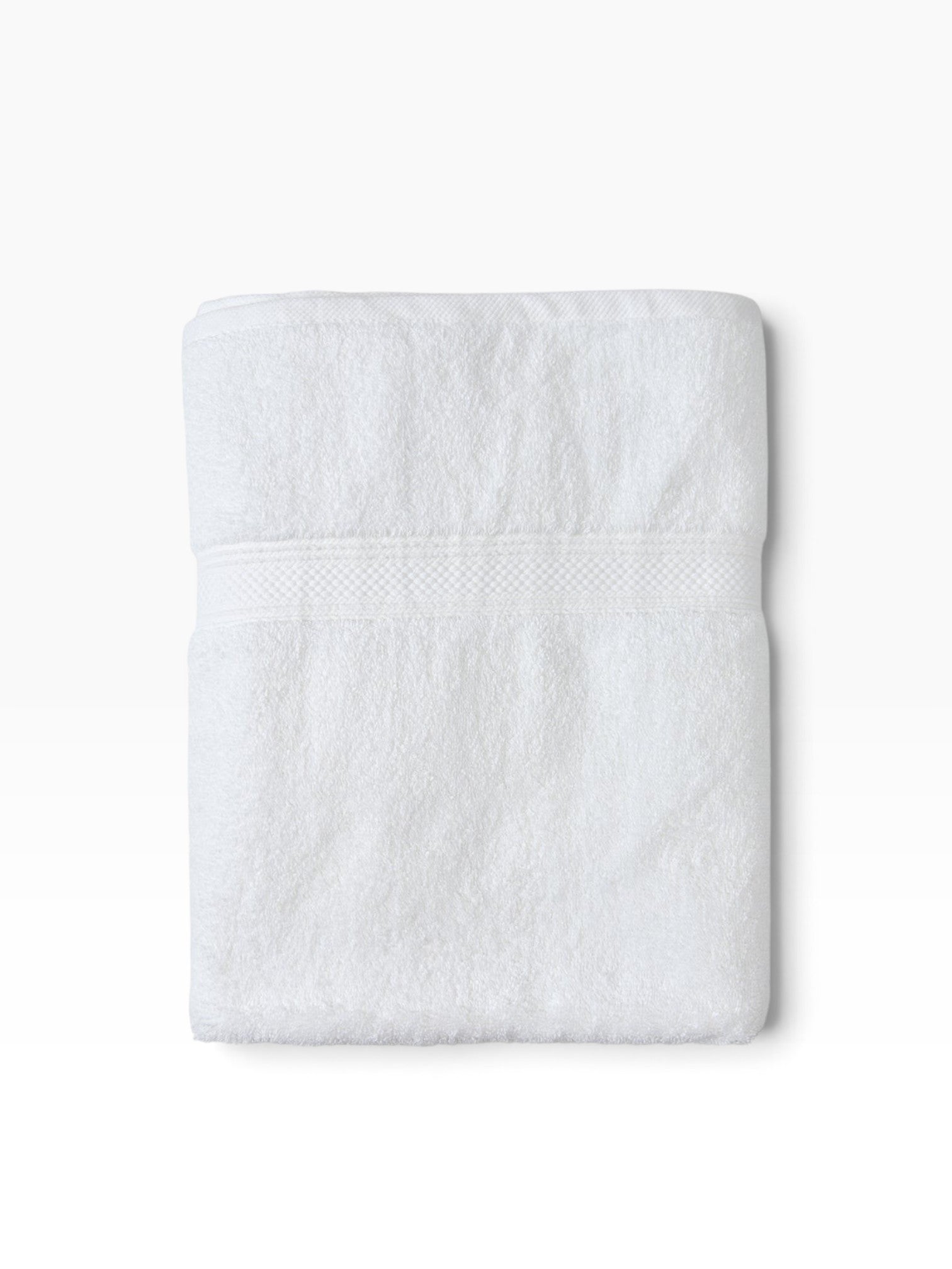 Valiant Products white plush cotton bath mat with a textured dobby border design, folded for a clean look.