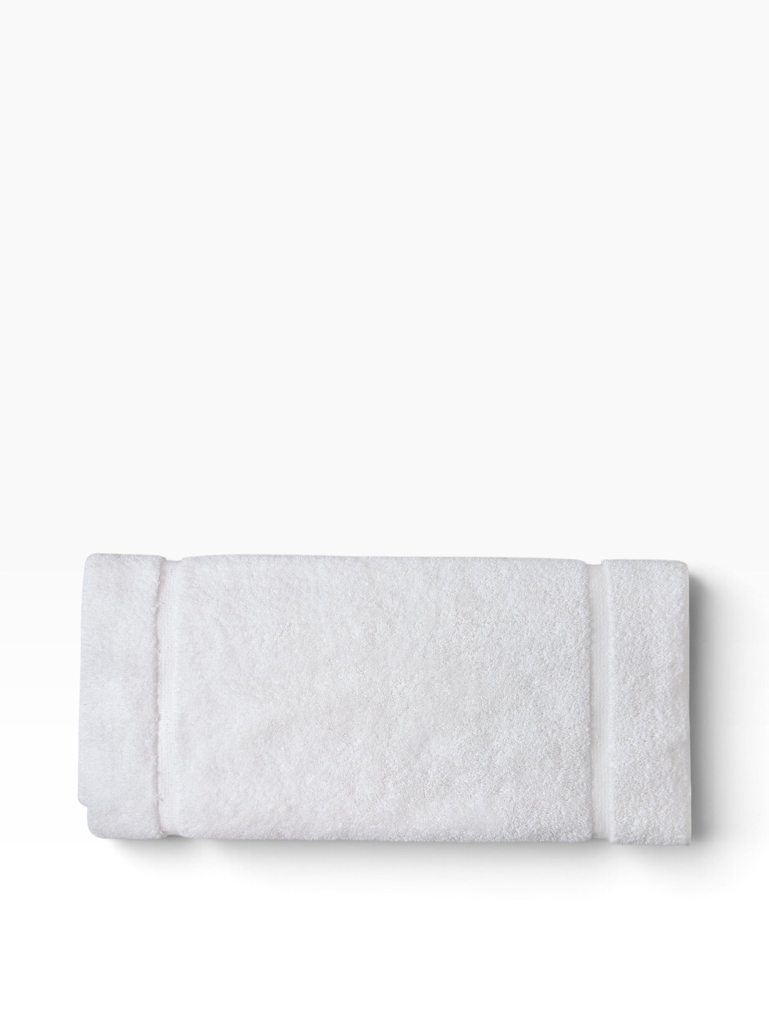 Valiant Products white plush cotton bath mat with a textured dobby border design, folded for a clean look.