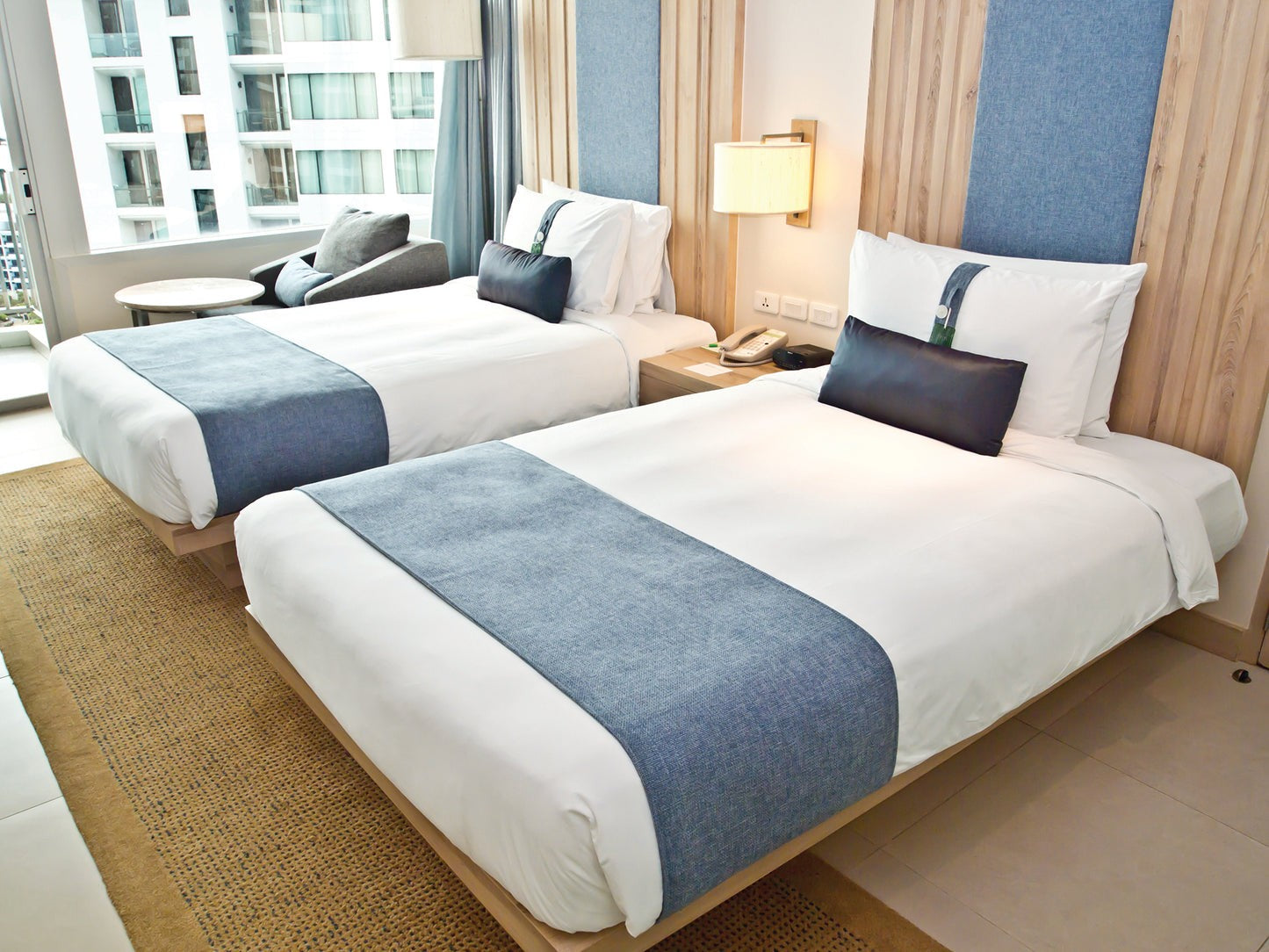 Valiant Products bright white T-200 cotton blend pillowcases styled on twin beds in a modern hotel room setting.