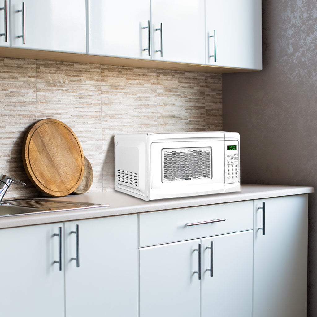Valiant Products white Danby 0.7 cu. ft. countertop microwave with digital display sitting on a modern kitchen counter