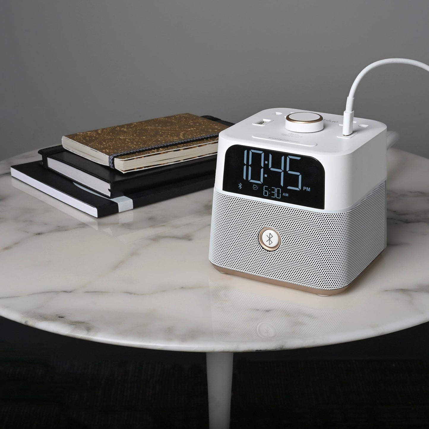 Valiant Products white CubieBlue alarm clock with Bluetooth speaker, USB ports, and digital display on marble table.