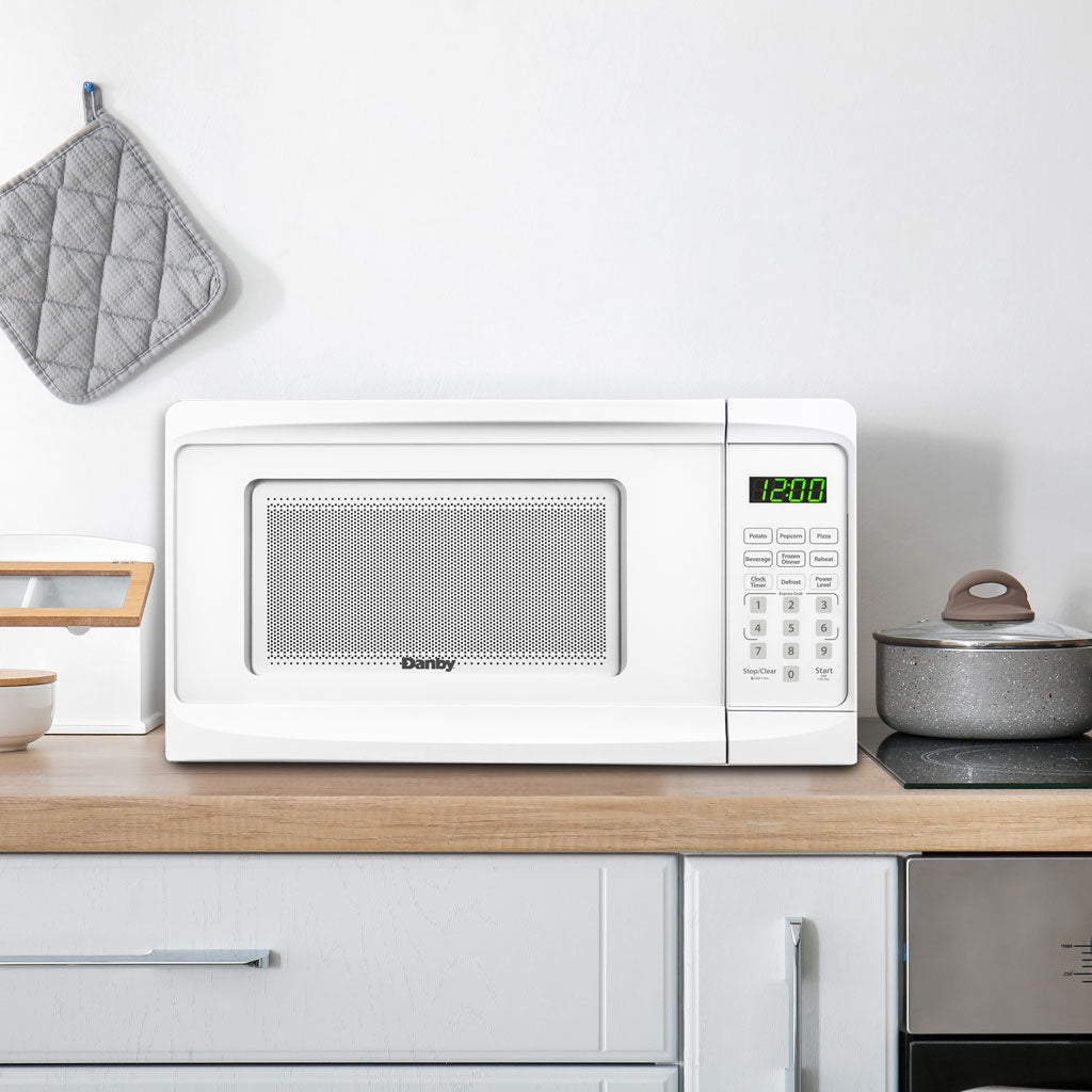 Valiant Products white Danby 0.7 cu. ft. countertop microwave with digital display and child safety lock on a counter