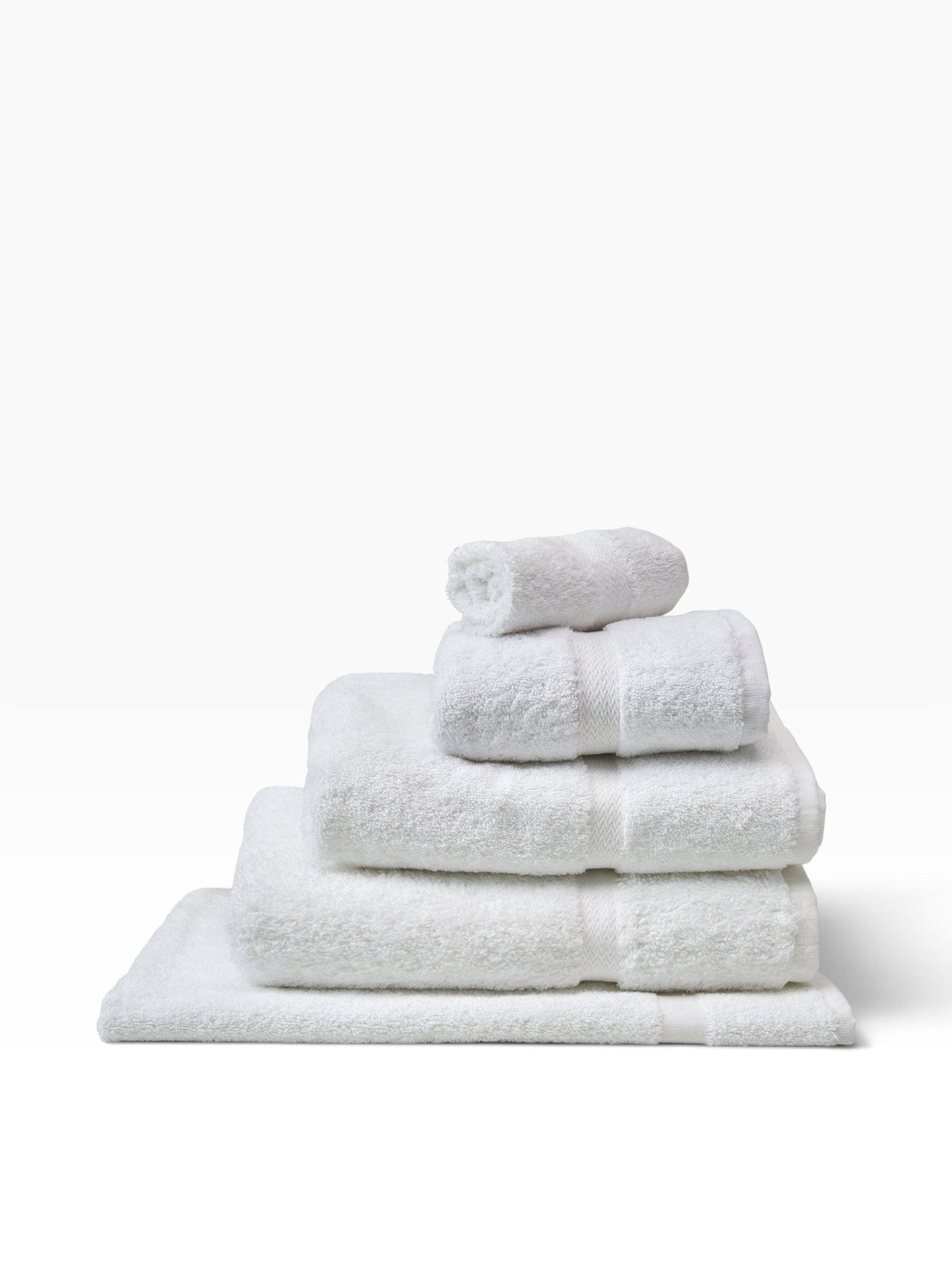 Valiant Products white cotton-blend bath mats stacked with elegant dobby border design for hotel use