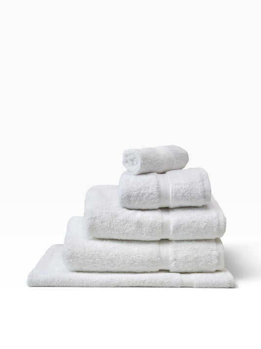 Valiant Products white cotton-blend bath mats stacked with elegant dobby border design for hotel use
