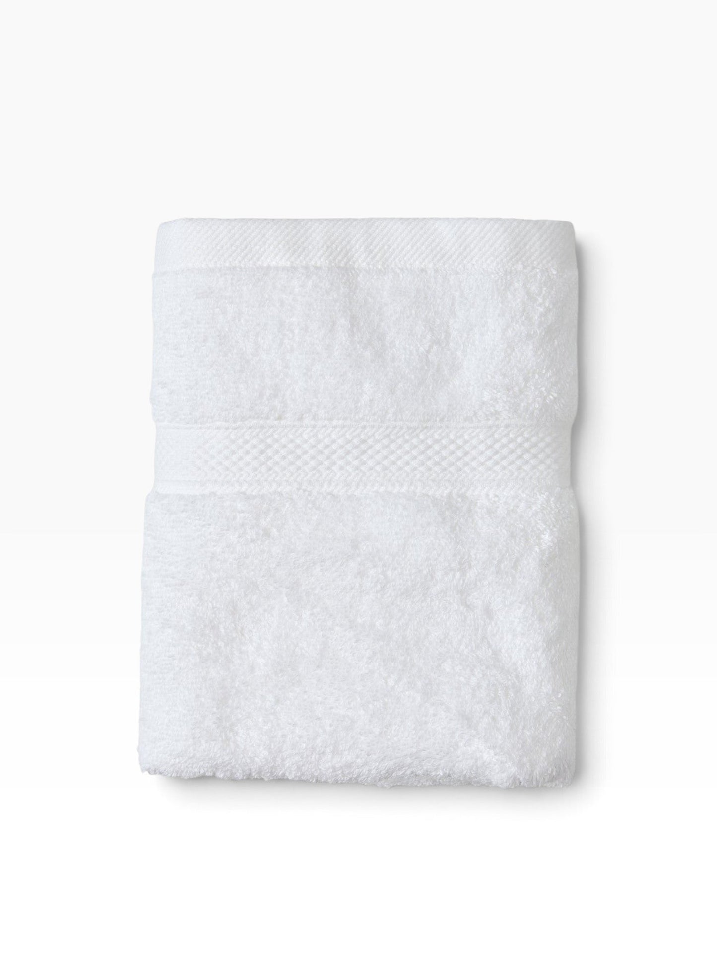 Valiant Products white plush bath towel featuring a decorative dobby border and soft cotton-polyester terry pile.