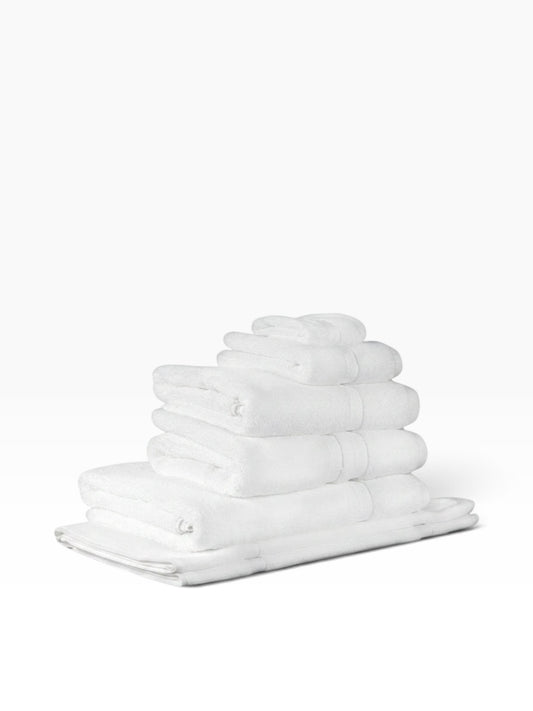 Valiant Products white Simplicity dobby border bath towels stacked neatly, featuring soft cotton loops.