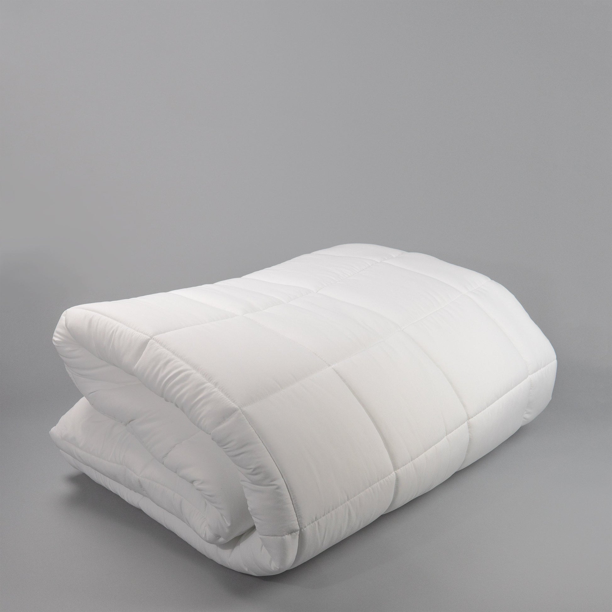 Valiant Products white microfiber down alternative comforter with 8-inch box stitch quilting for hospitality use.