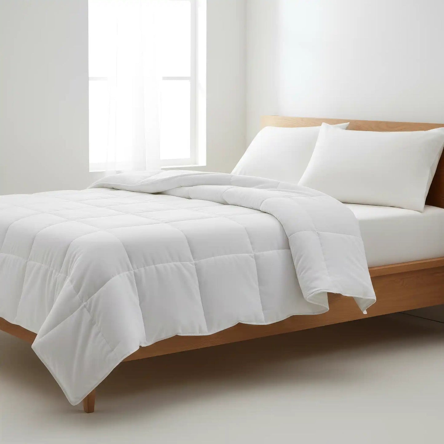 Valiant Products Ultra Touch white microfiber down alternative comforter with 8-inch quilted box stitch on a bed.