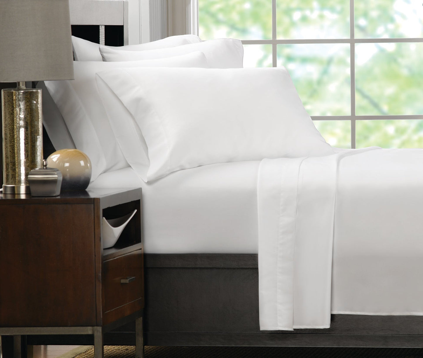 Valiant Products Ultra Touch white microfiber pillowcases on a neatly made bed in a bright, modern bedroom setting.