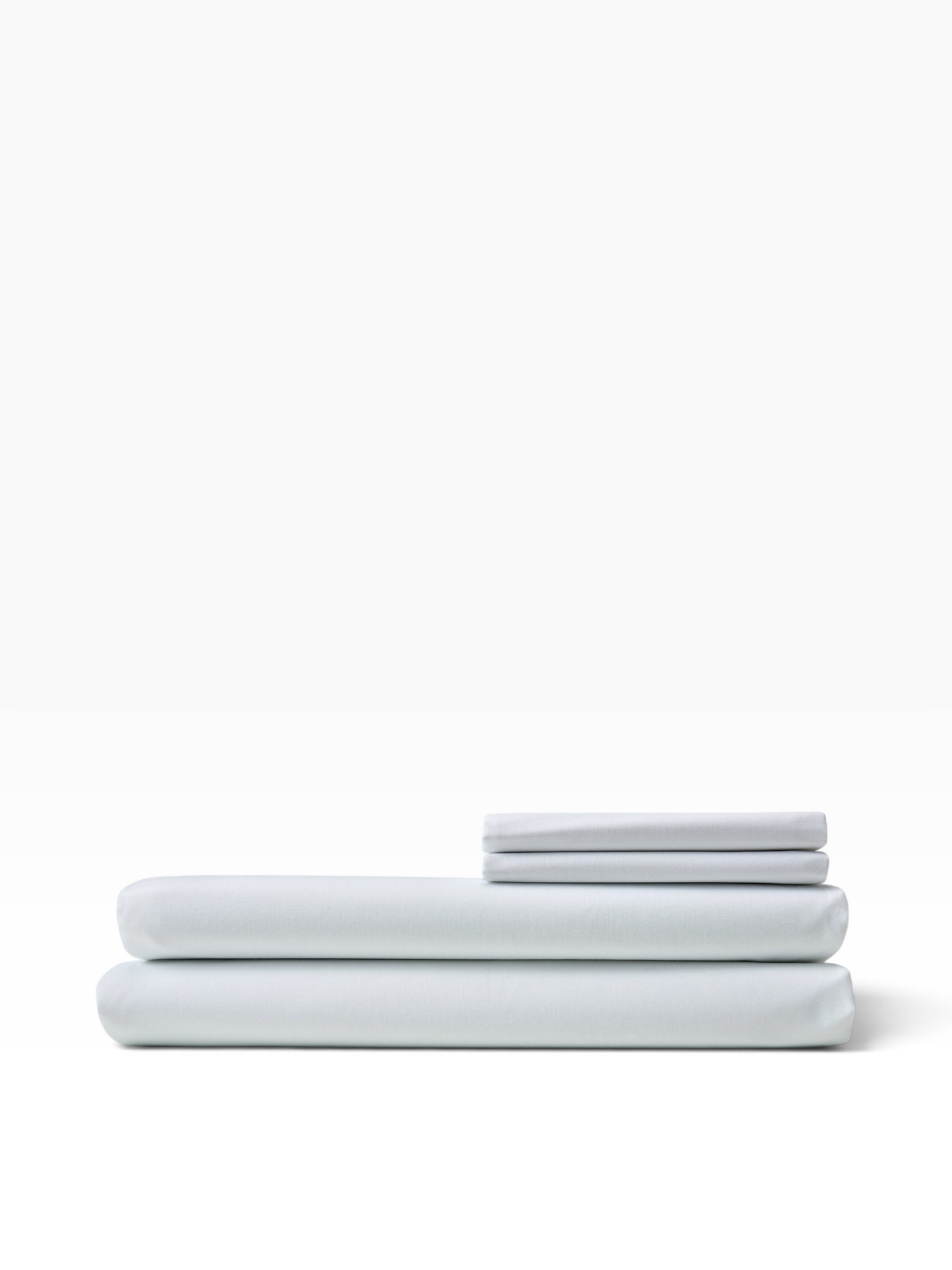 Valiant Products white T-180 percale flat sheets folded in a stack, made from a durable cotton-polyester blend.