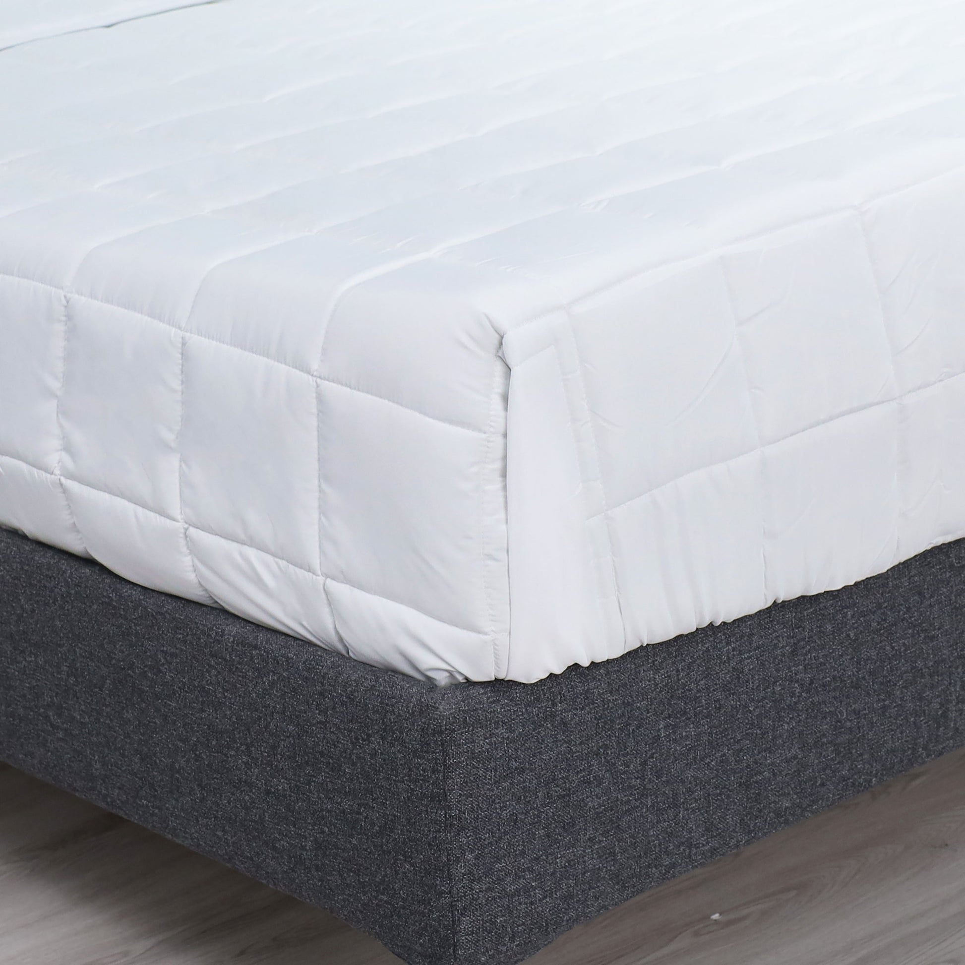 Valiant Products Ultra Touch FLEX white quilted microfiber down alternative blanket on a bed with box stitch detail